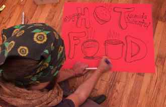 Phillip Gladkov making signs for the Community Solidarity Vegan Thanksgiving