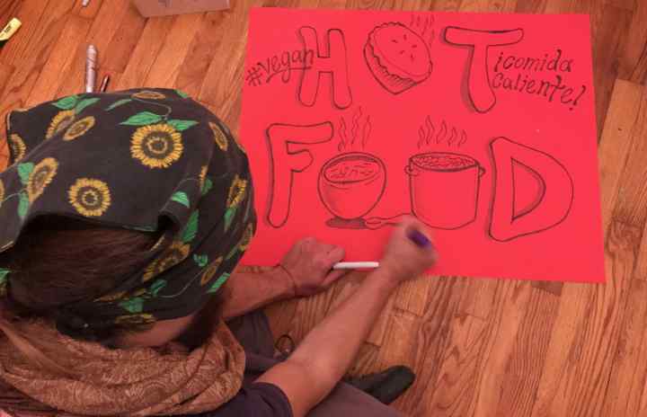 Phillip Gladkov making signs for the Community Solidarity Vegan Thanksgiving